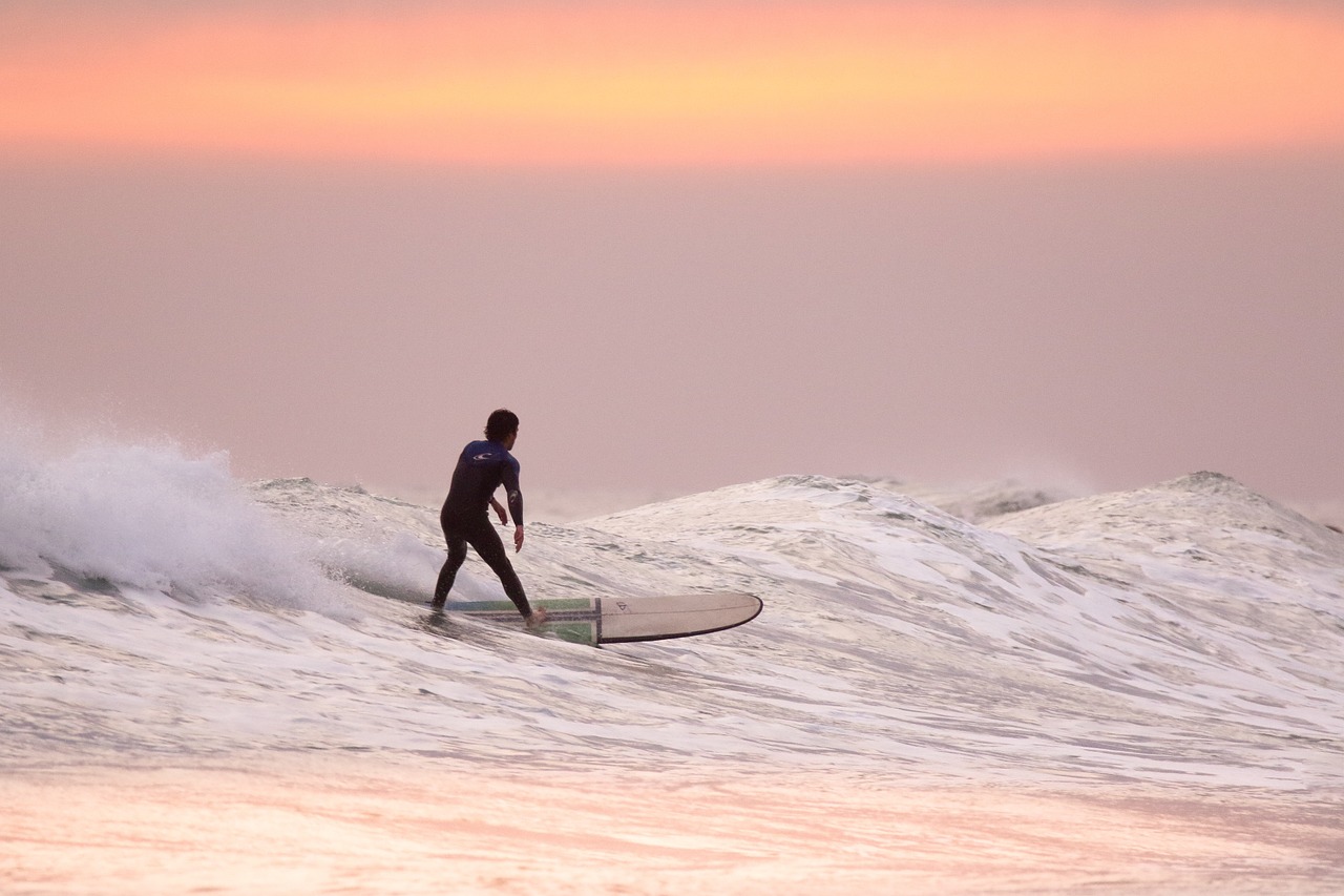 An individual surfing at sunet